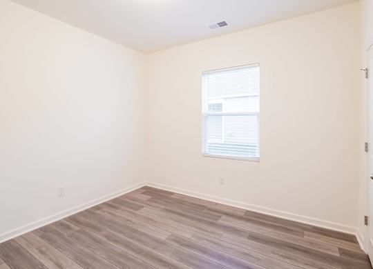 a room with a window and wooden floors