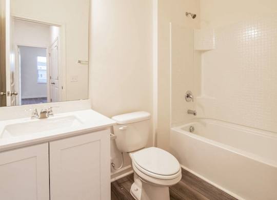 a bathroom with a toilet and a tub and a sink