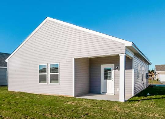 a small white house with a white door and a lawn