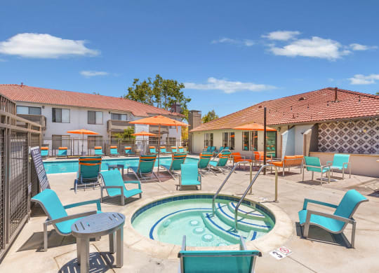 a resort style pool with blue chairs and a hot tub