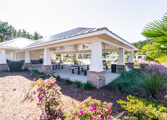 a covered patio with tables and benches in a pavilion