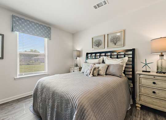 Bedroom with gray quilted bedding, black headboard, and coastal decor.
