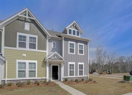 A two-story house with a green and grey exterior.