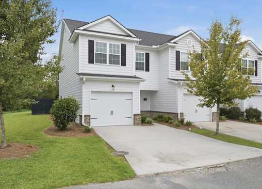 A two-story house with a garage and a driveway.