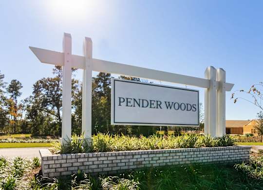 a sign that reads pender woods in front of a building