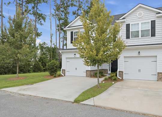 A two-story house with a white garage door.