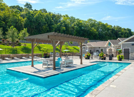 a swimming pool with tables and chairs next to a resort style pool