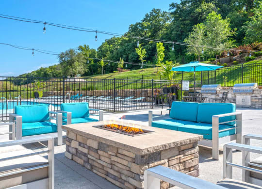 a patio with a fire pit and chairs and umbrellas