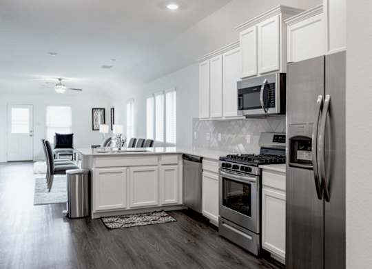 a kitchen with white cabinets and stainless steel appliances