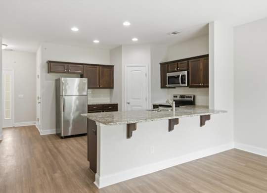 A kitchen with a white island and stainless steel appliances.