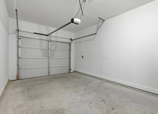A white wall with a garage door opener.