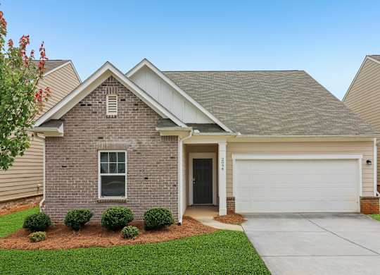 A house with a grey roof and a white garage door.