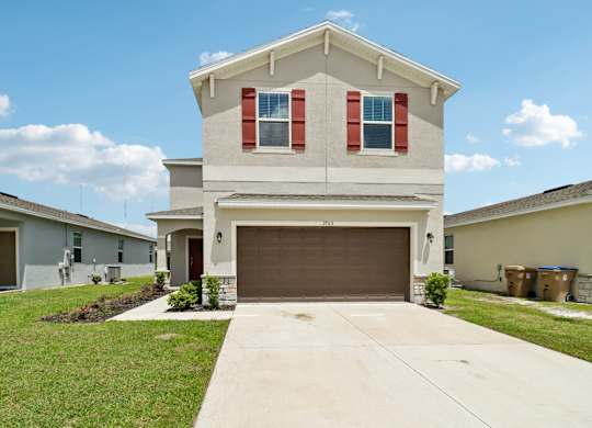 A house with a brown garage door and red shutters.