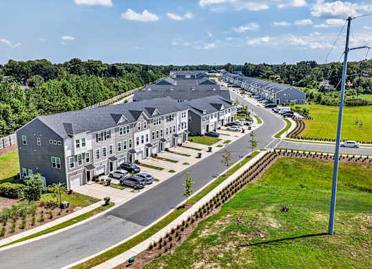 A large grey building with a parking lot in front of it.