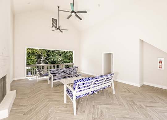 A living room with a couch and a fan.