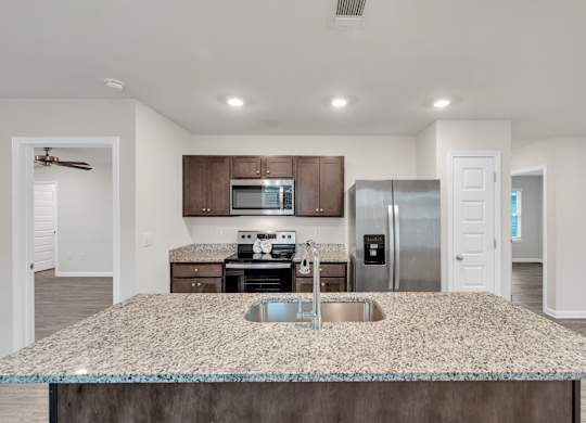 A kitchen with granite countertops and stainless steel appliances.