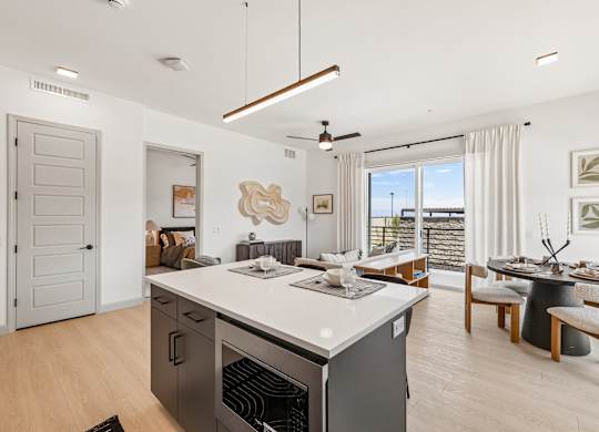A modern kitchen with a large island and a dining area.