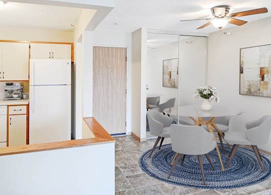 A modern dining room with a white table and chairs.
