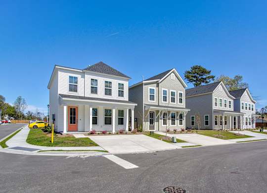 Park Circle, SC Home Rentals - Sumner Village - Row of Two-Story Homes with Windows, Paved Driveways, Grass Areas, and a View of the Street.