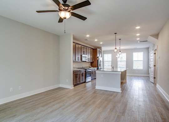 an open kitchen and living room with a ceiling fan