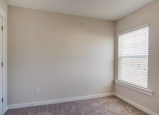 an empty room with a window and a door