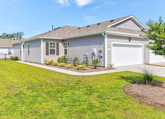 a blue house with a garage and a lawn