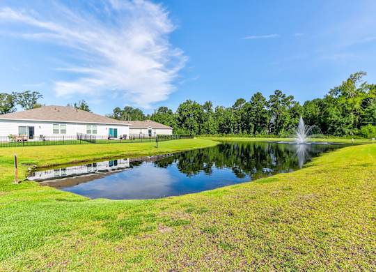 Myrtle Beach, SC Homes for Rent - The Palmer at Carolina Forest - Pond with Fountain, Surrounded by Maintained Grass Lawn, Trees, and Homes