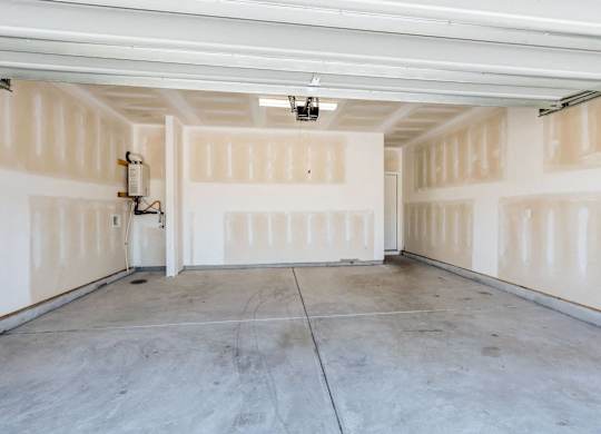 the inside of a garage with white walls and a concrete floor