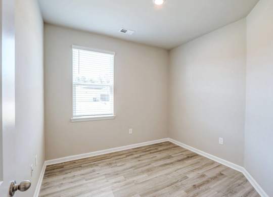an empty room with white walls and a window