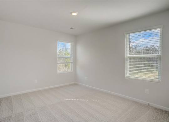 A room with two windows and a carpeted floor.