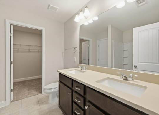 A bathroom with a sink, mirror, and toilet.