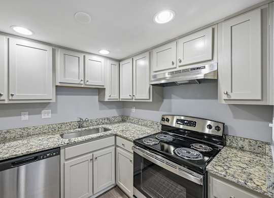 A kitchen with granite countertops and stainless steel appliances.