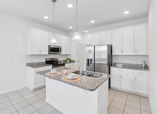 A kitchen with white cabinets and granite countertops.