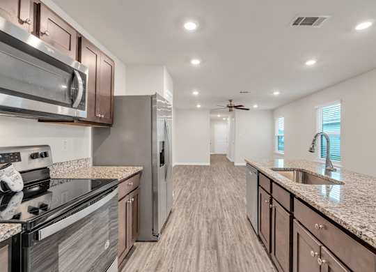 A modern kitchen with a stove top oven and a refrigerator.