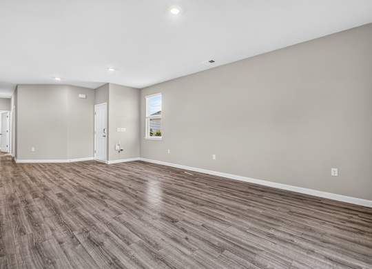 A room with wooden flooring and white walls.
