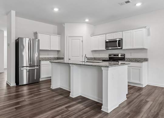 A kitchen with white cabinets and a stainless steel refrigerator.