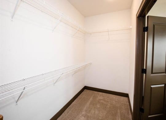 a walk in closet with a white wall and a closet door