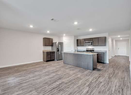 A modern kitchen with a wooden floor and white walls.