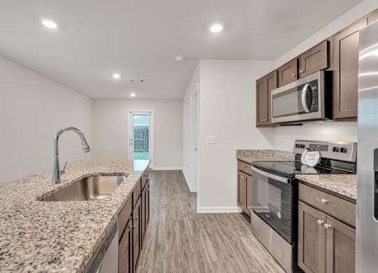 A kitchen with granite countertops and stainless steel appliances.