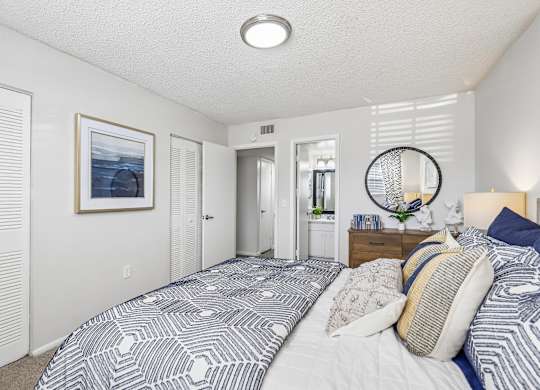 A bedroom with a large bed and a picture on the wall.