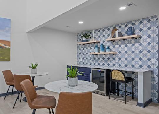 A room with a table, chairs and a painting on the wall.