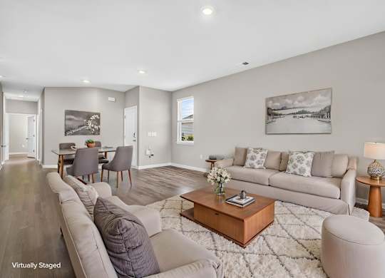 A living room with a grey couch, a coffee table, and a painting on the wall.