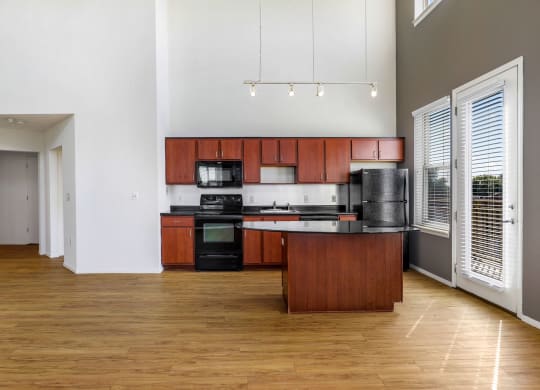 a kitchen with wooden cabinets and a black countertop
