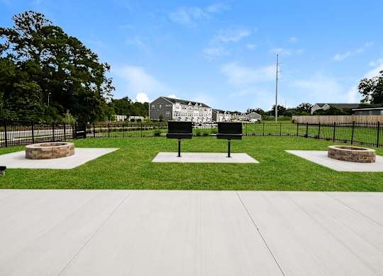 A park with a white sign and a black fence.