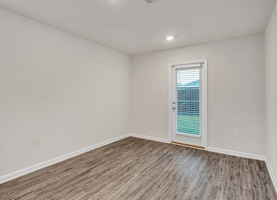 A room with a wooden floor and a white door.