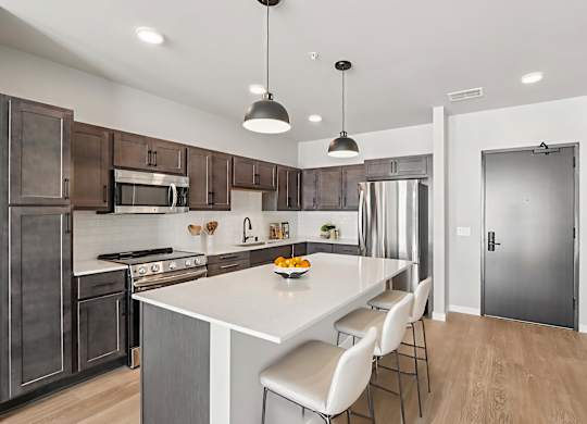A modern kitchen with a large island and stainless steel appliances.