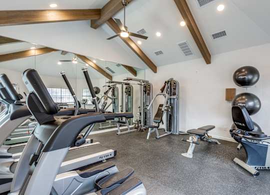A spacious gym with a variety of equipment including treadmills, weights, and exercise balls.