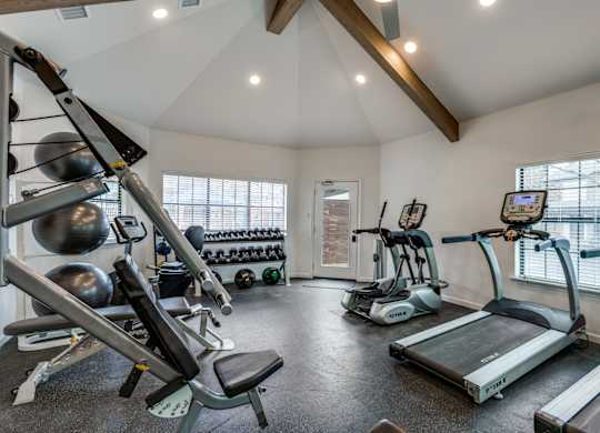A well-equipped home gym with a variety of exercise machines.
