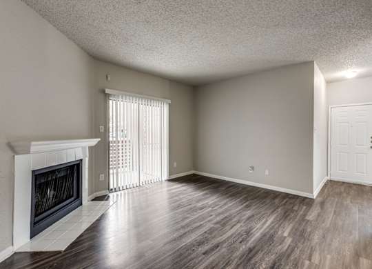 A room with a fireplace and wood flooring.
