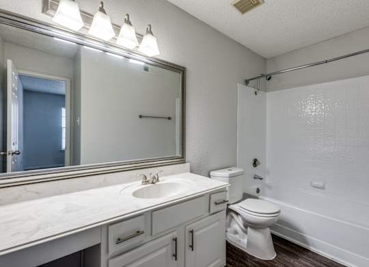 A white bathroom with a sink, toilet, and bathtub.